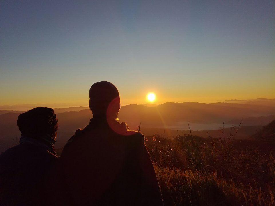 Beautiful view of sunset in Keokradong, Bangladesh. Two couple are enjoying the sunset view from the top of the mountain