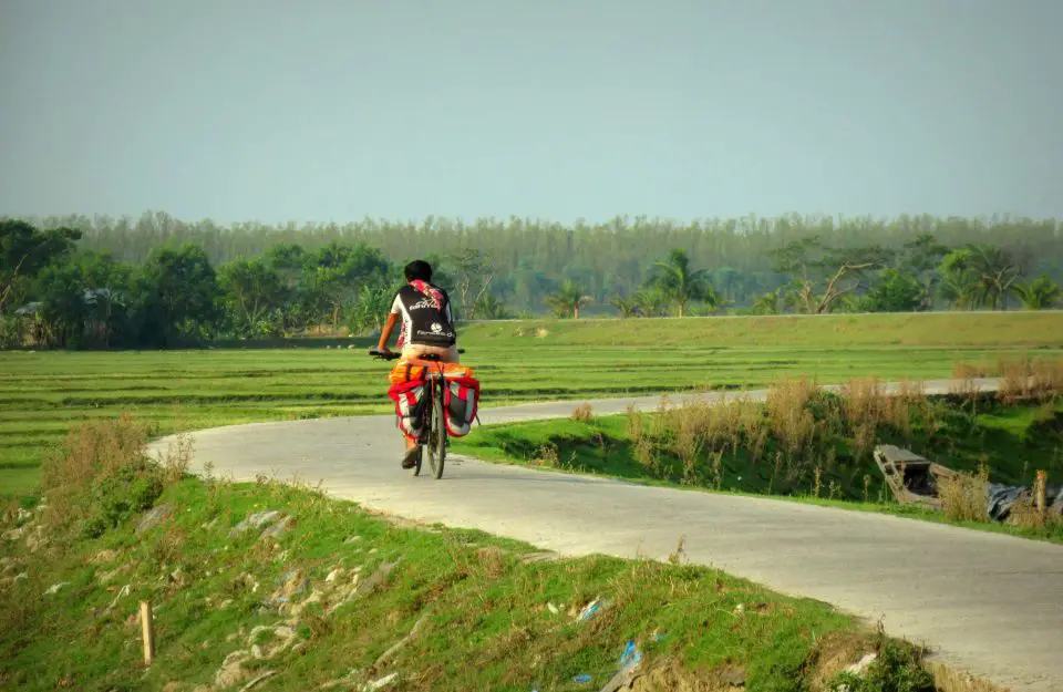 A villager riding on a cycle in beautiful road of Manpura Island, Bangladesh