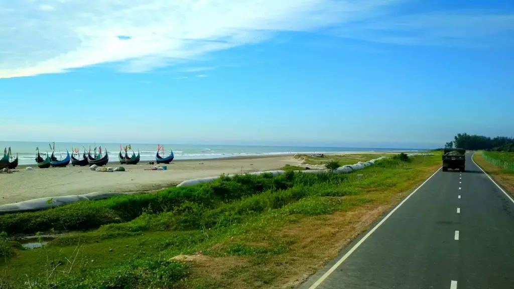 Sea beach view from the marine drive, some boats are at the sea bank and a card in the road, Cox's Bazar, Bangladesh.