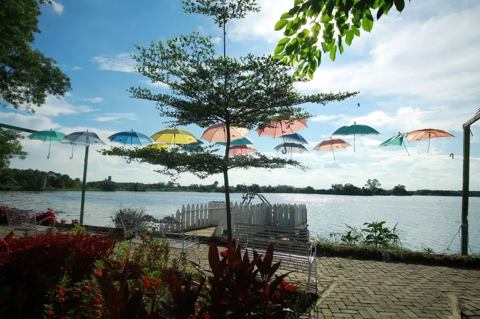 Things to do in Medan. Visit Danau Siombak lake with your family and friends. Beautiful Umbrella and lake are seen.