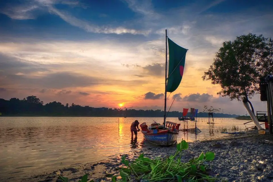 Top tourist attractions in Mymensingh, Bangladesh. A boat and boatman in the Bramhaputra river in the time of sunset.