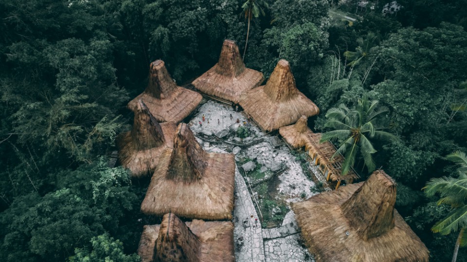 Straw roof huts. Traditional Sumbanese village. Jungle. Cone shape authentic houses "ratenggaro" intermingle with tombs. Sumba island, Indonesia. Best places to visit in Sumba