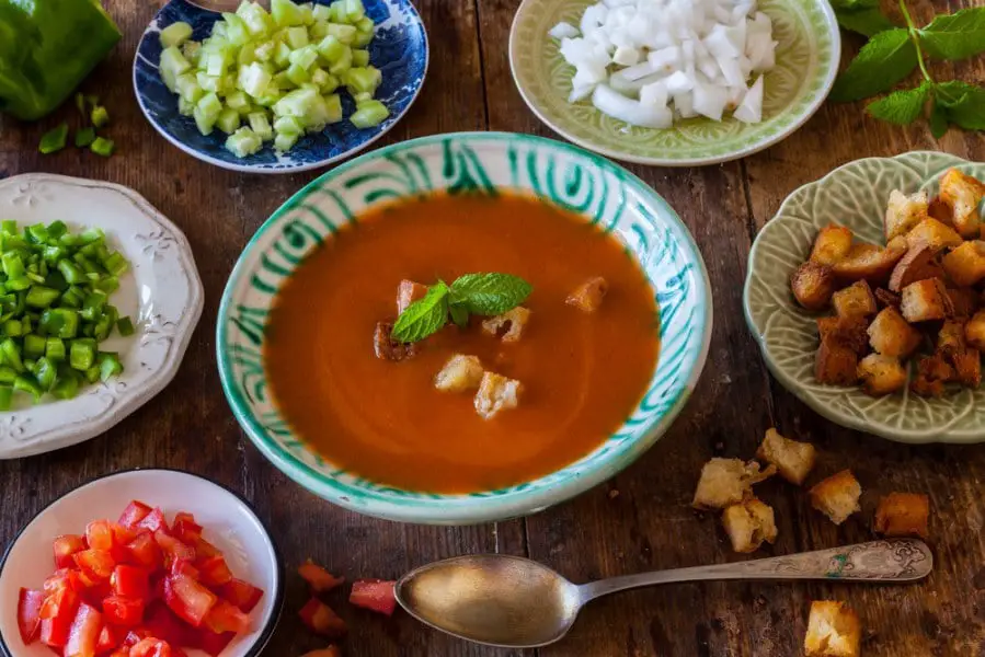 Spanish Cuisine. Gazpacho. Andalusian cold soup served the authentic way with garnishes served separately. Rustic retro vintage ambiance.Best Typical Foods Of Andalusia You Should Taste