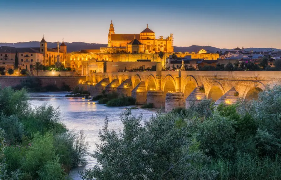 Best Free Cordoba Tours : Panoramic night sight in Cordoba, with the Roman Bridge and Mezquita on the Guadalquivir River. Andalusia
