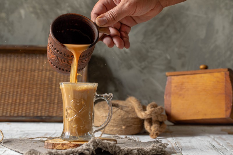 a person pouringtea into a glass cup