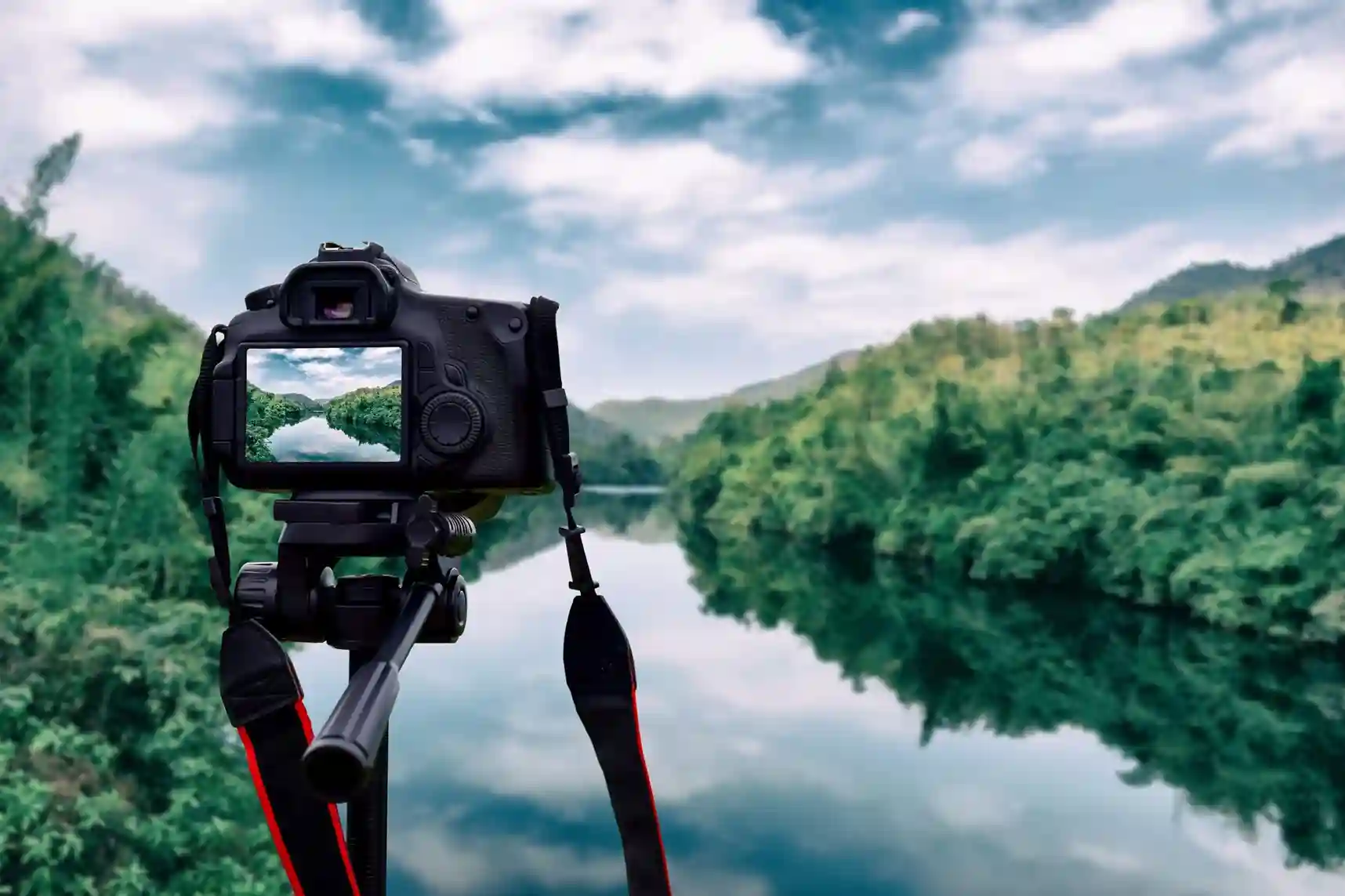 A camera on a tripod capturing a scenic river view